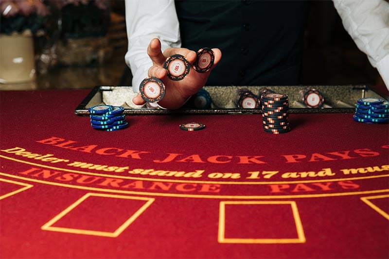 Blackjack dealer holding chip