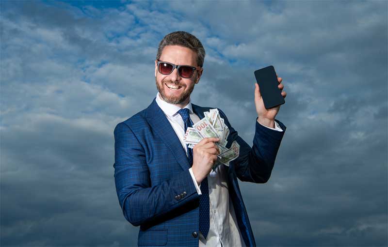 Man in blue suit with money and cell phone